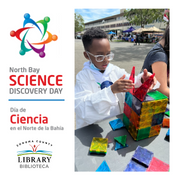 Boy playing with magnatiles with lab coat on and safety glasses