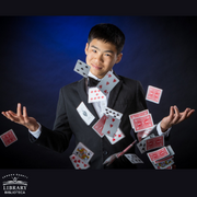Photo of James Chan with playing cards in the air in front of him. 