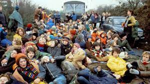 Image: protesters sit in front of a vehicle at Greenham Common in England