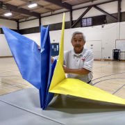 Photo of instructor Henry Kaku with his giant origami paper crane. 