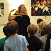 Photo of an SF Opera singer leading a group of kids.