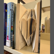 Photo of a book with pages folded into a 3D heart shape.