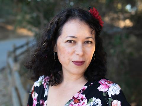 Headshot of the author wearing a black floral shirt.
