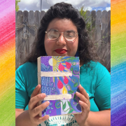 Photo of artist Amanda Ayala holding an art journal she handmade. 
