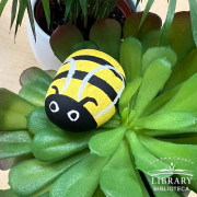 Photo of a rock painted in the image of a honey bee.