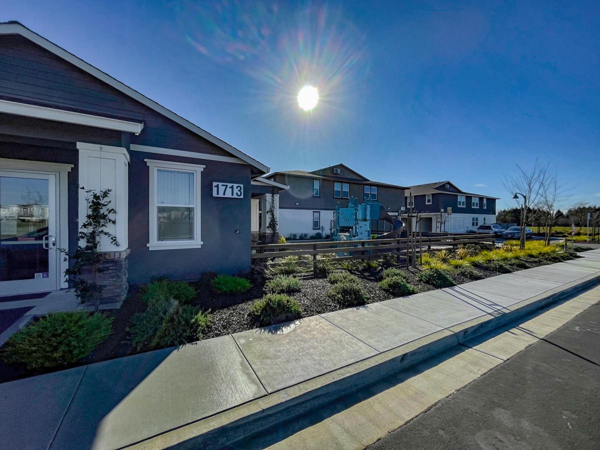 Image is of the front of houses on a sunny day.